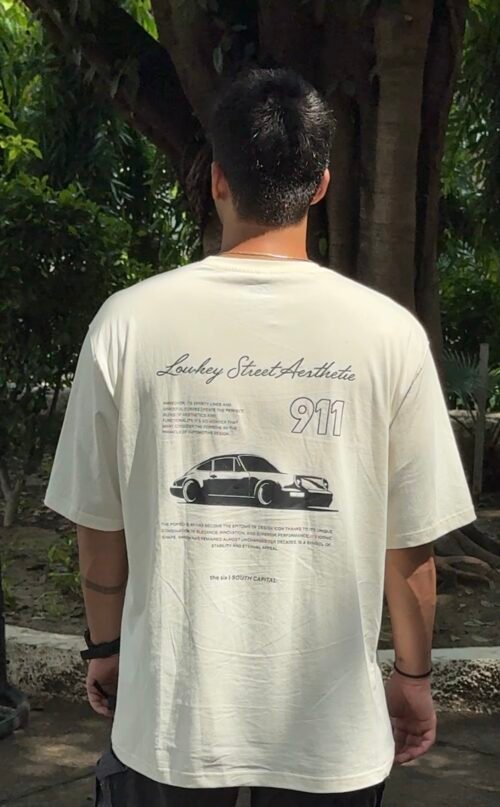 A clean cream oversized tee featuring a bold Porsche 911 graphic on the back — minimal in the front, streetwear statement at the back