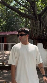 A clean cream oversized tee featuring a bold Porsche 911 graphic on the back — minimal in the front, streetwear statement at the back