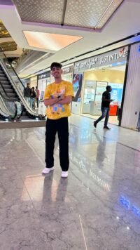 A vibrant yellow oversized tee with a quirky skeleton graphic, playful blue backdrop, and bold streetwear vibes — built for statement looks. Zeal Store Online